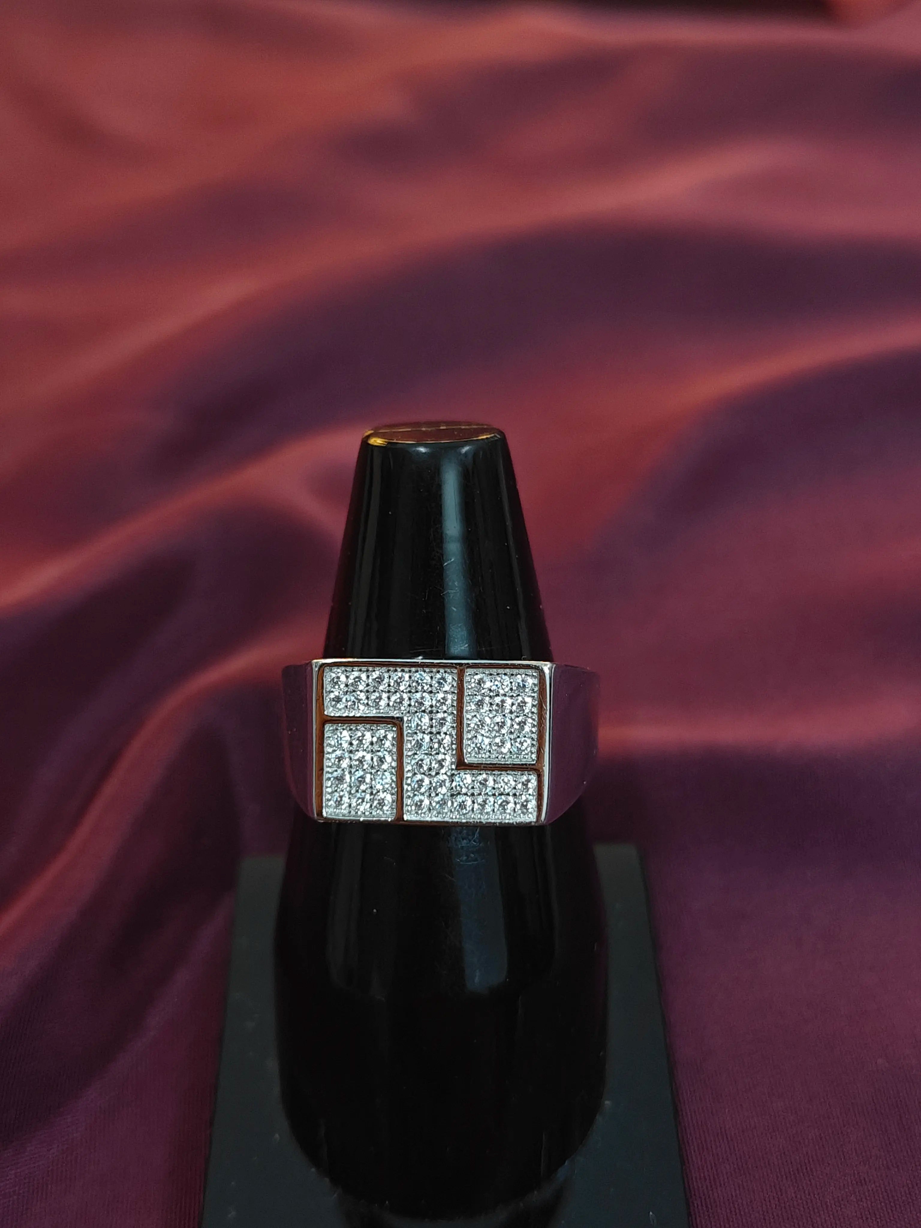 Black ring with diamond-studded band on a purple fabric background